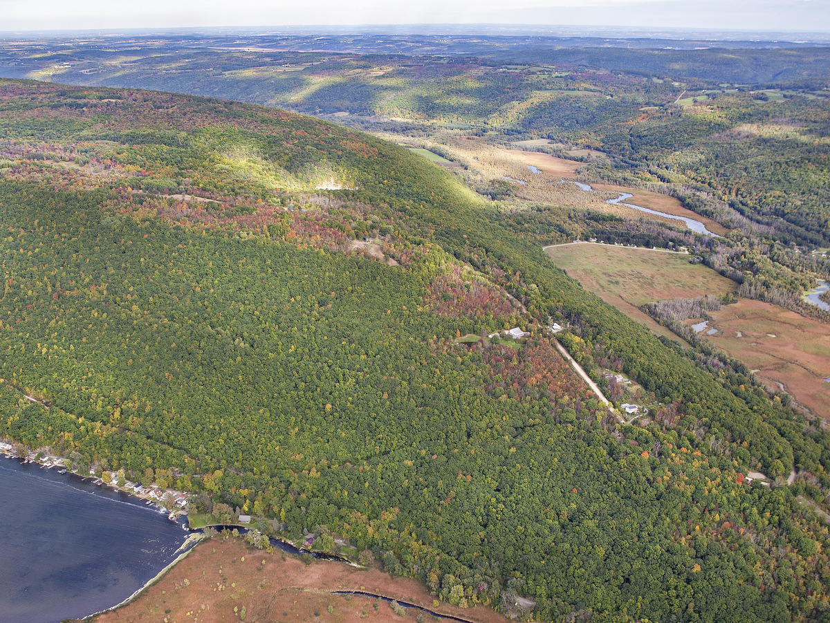 An aerial view of green hills above a lake and small river